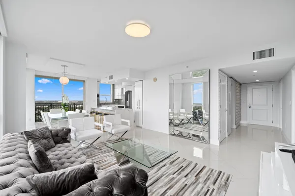 a living room with furniture and view of kitchen