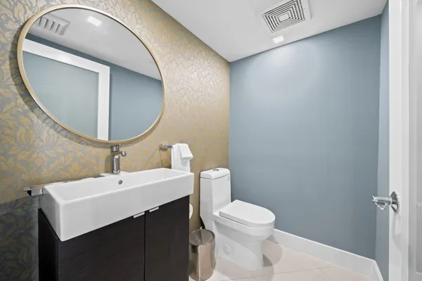 a bathroom with a sink mirror and toilet
