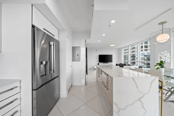 a large white kitchen with a large window