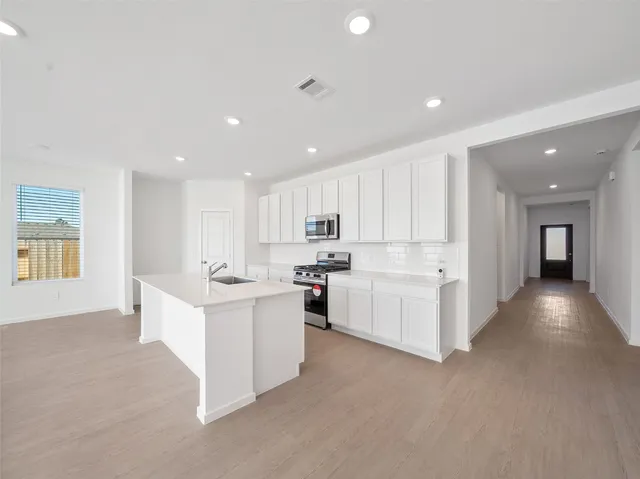 a view of kitchen center island with white cabinets