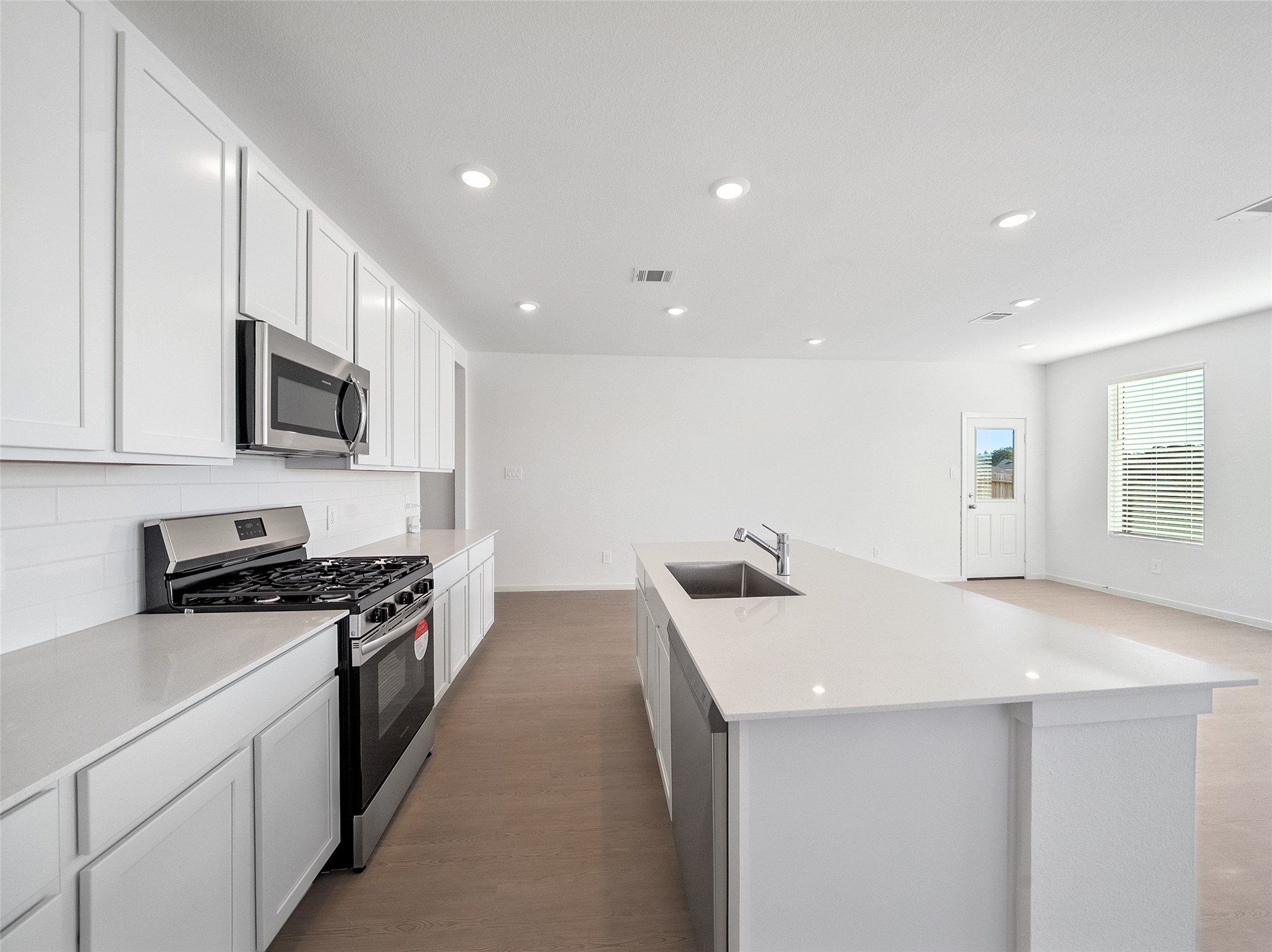 826 Ridgewood Cliffs Willis, TX 77378 - Photo 20 of 26 a kitchen with stainless steel appliances a stove top oven a sink a refrigerator white cabinets and wooden floor