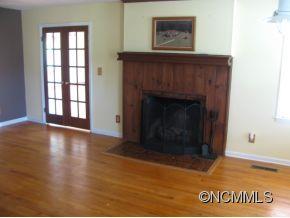 963 McEntire Road Tryon, NC 28782 - Photo 2 of 9 a view of an empty room with wooden floor and a fireplace