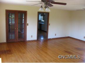 963 McEntire Road Tryon, NC 28782 - Photo 4 of 9 an empty room with wooden floor and ceiling fan