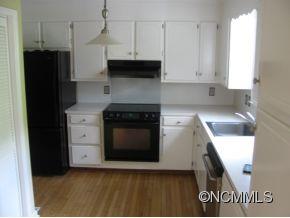 963 McEntire Road Tryon, NC 28782 - Photo 5 of 9 a kitchen with stainless steel appliances a stove a refrigerator a sink and dishwasher with wooden floor