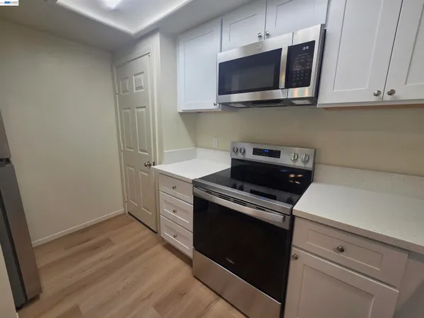 a kitchen with a sink a refrigerator and chandelier