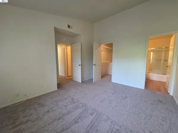 an empty room with windows and closet area