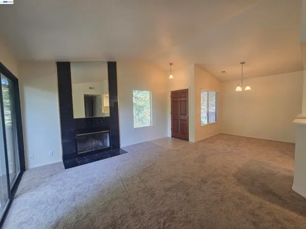 a view of an empty room with a fireplace and a window