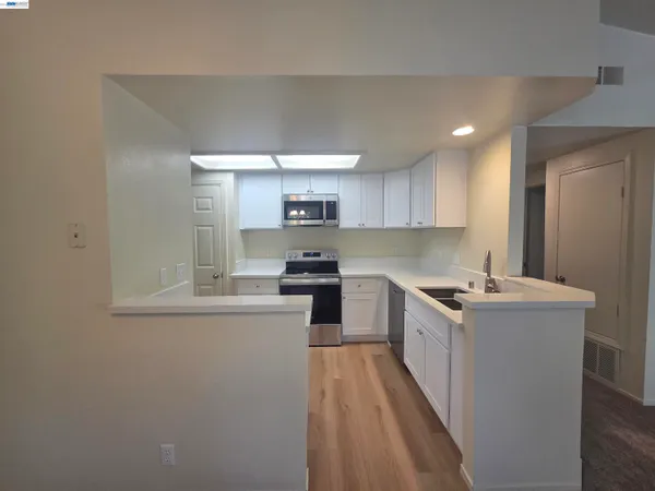 a kitchen with sink a microwave and cabinets
