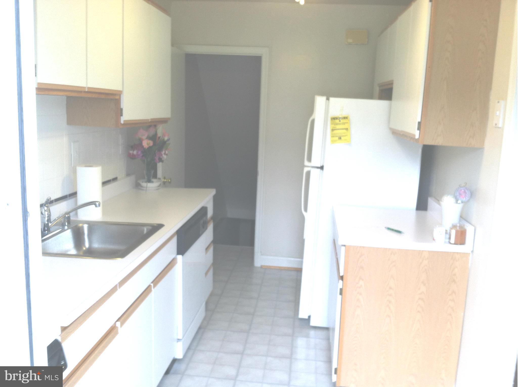 4804 Greencrest Road Baltimore, MD 21206 - Photo 3 of 3 a kitchen with a sink and a refrigerator