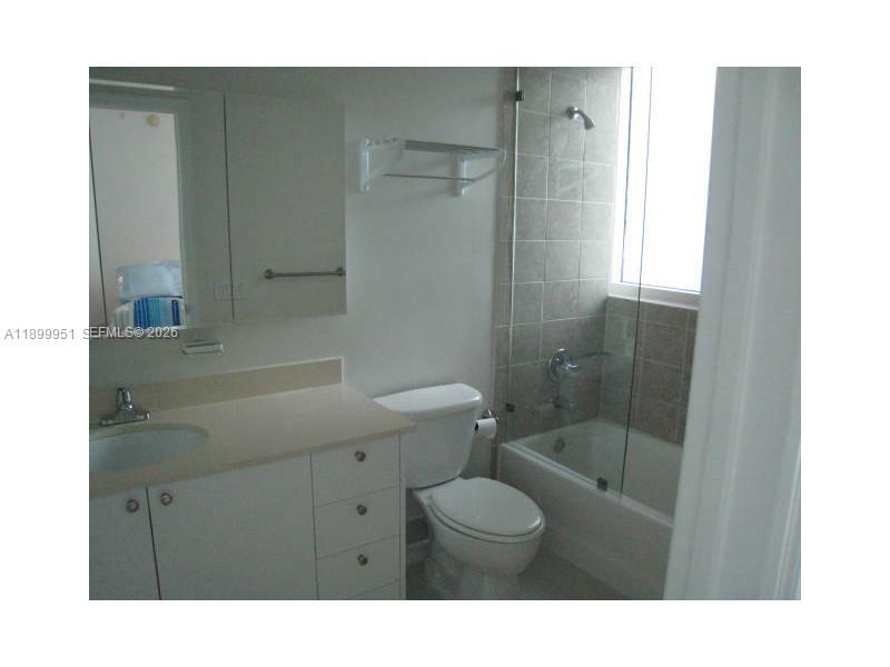 60 Southwest 13th Street, Unit 1900 Miami, FL 33130 - Photo 42 of 96 a bathroom with a sink a toilet a shower and a mirror