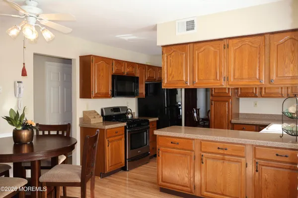 a kitchen with stainless steel appliances granite countertop a stove a sink dishwasher and a microwave oven with wooden floor