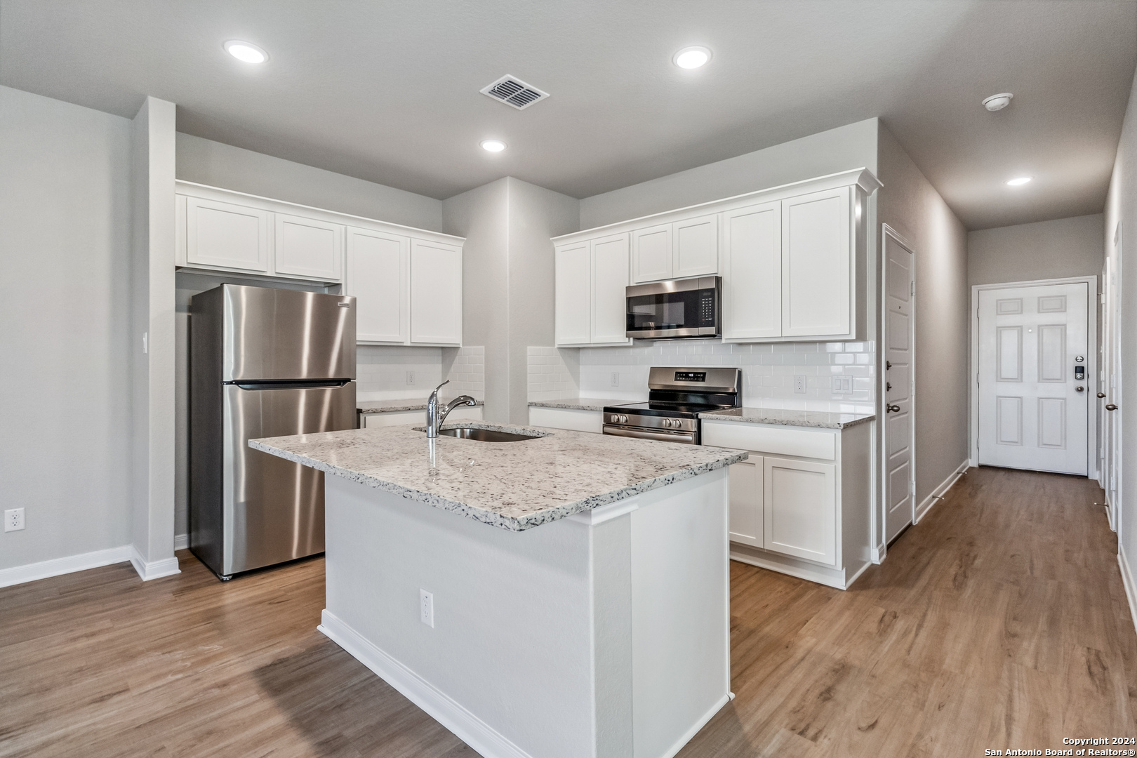 3928 Abbott Pass St. Hedwig, TX 78152 - Photo 4 of 35 a kitchen with kitchen island a refrigerator sink and microwave