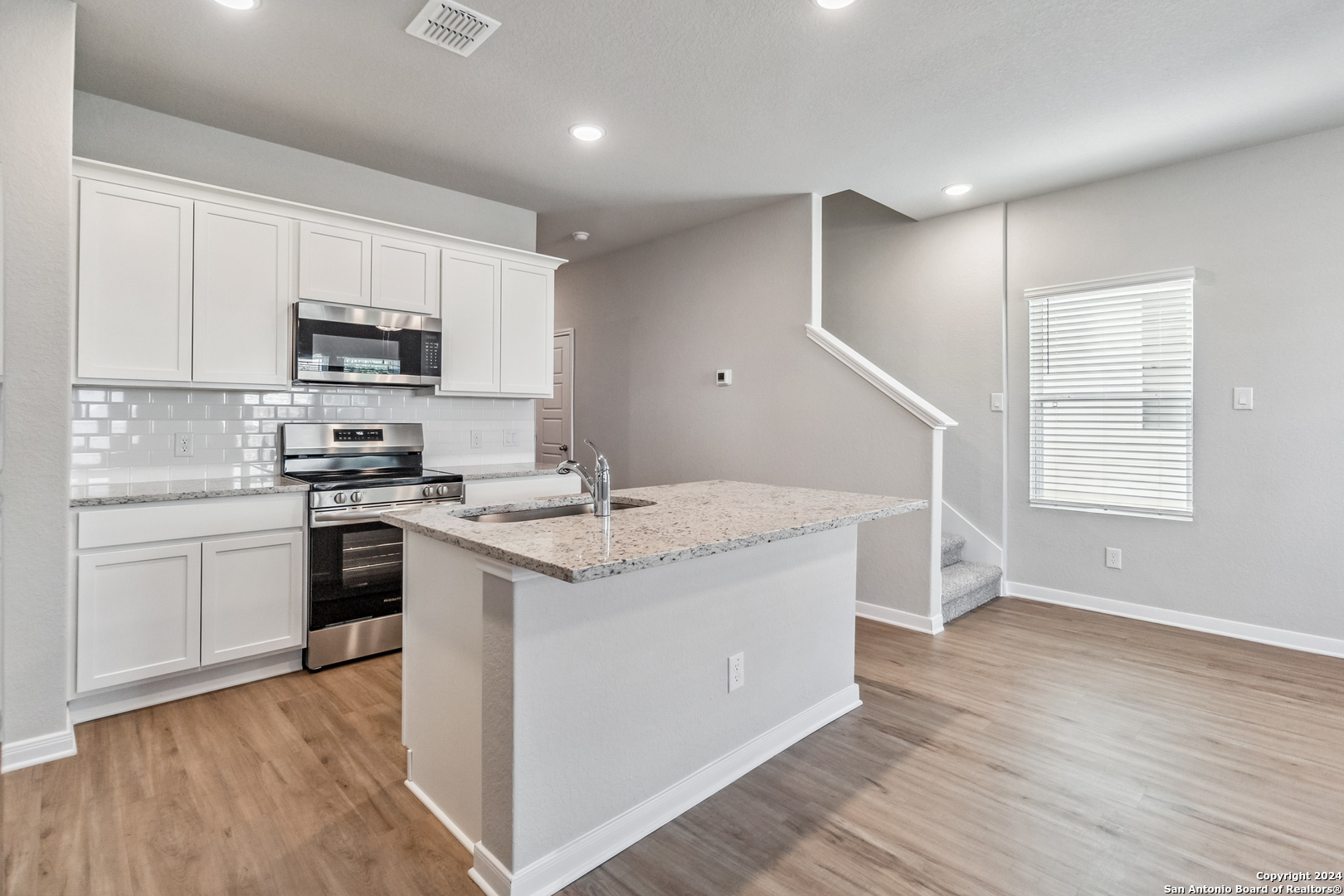 3928 Abbott Pass St. Hedwig, TX 78152 - Photo 5 of 35 a kitchen with stainless steel appliances granite countertop a stove a sink and a refrigerator