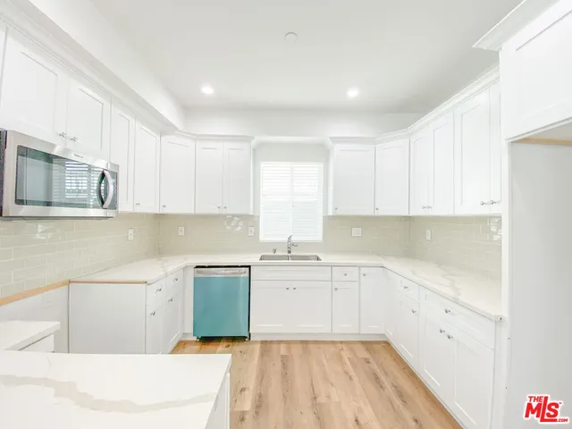 a kitchen with a sink stove and cabinets