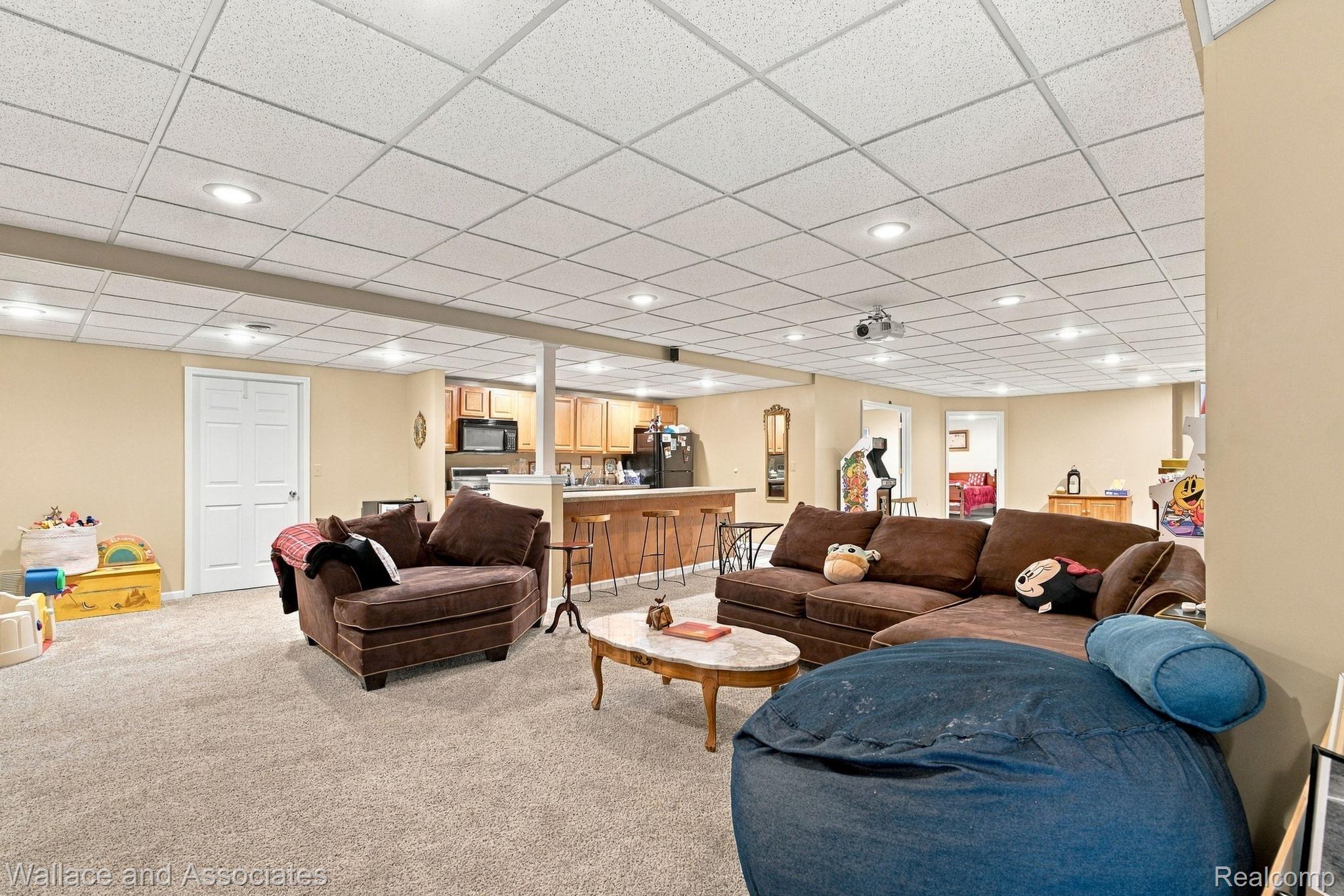 17076 27 Mile Road Ray, MI 48096 - Photo 45 of 63 Spacious recreation room featuring recessed lighting, light-colored carpeting, and a built-in wet bar with wood cabinetry and a breakfast bar