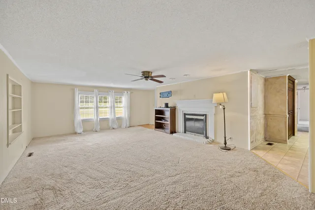a view of a livingroom with a fireplace and window