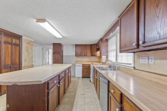 a kitchen with a stove a sink dishwasher and a refrigerator