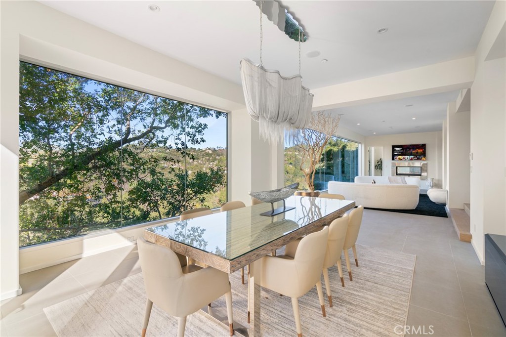 9716 Oak Pass Road Beverly Hills, CA 90210 - Photo 20 of 63 a dining room with wooden floor a chandelier a glass table and chairs
