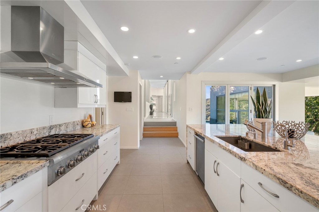 9716 Oak Pass Road Beverly Hills, CA 90210 - Photo 21 of 63 a large kitchen with stainless steel appliances granite countertop a lot of counter space and a sink