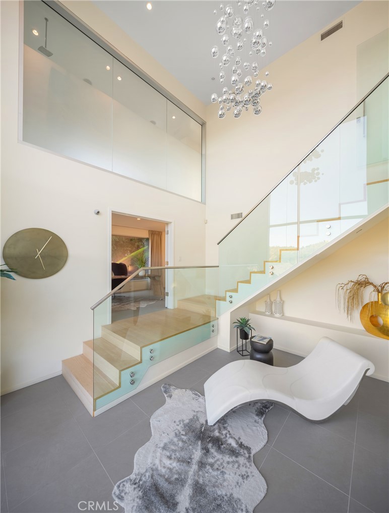 9716 Oak Pass Road Beverly Hills, CA 90210 - Photo 36 of 63 a living room with furniture and a chandelier