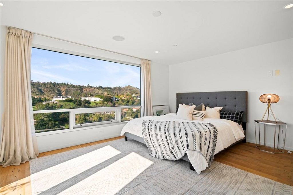 9716 Oak Pass Road Beverly Hills, CA 90210 - Photo 51 of 63 a bedroom with a large bed and a large window