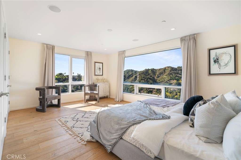 9716 Oak Pass Road Beverly Hills, CA 90210 - Photo 52 of 63 a bedroom with a bed and large windows