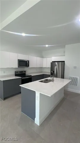 a large kitchen with stainless steel appliances a stove a sink dishwasher and a refrigerator