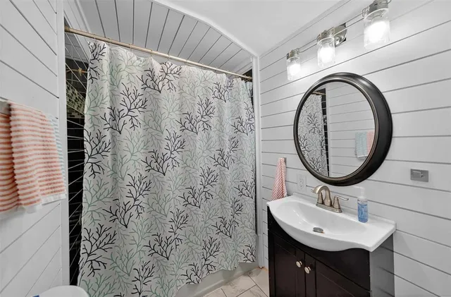 a bathroom with a sink a mirror and a shower