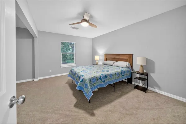a bedroom with a bed lamp and a window