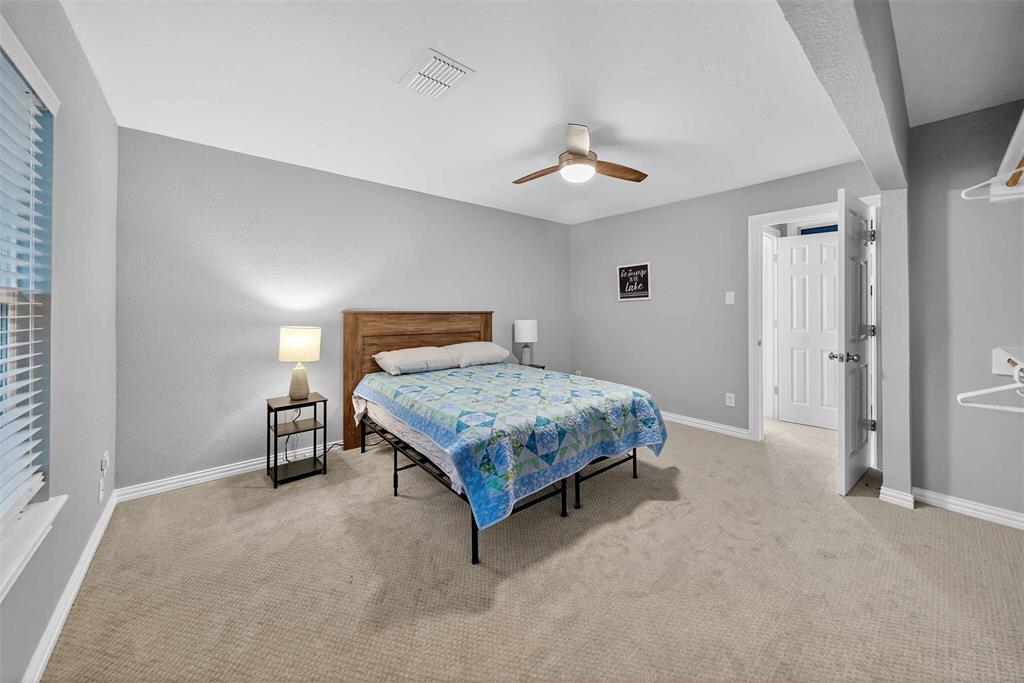 128 Armada Loop Payne Springs, TX 75156 - Photo 26 of 33 a bedroom with a bed and a chandelier