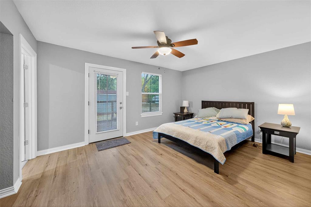 128 Armada Loop Payne Springs, TX 75156 - Photo 7 of 33 a bedroom with a large bed chandelier and a window