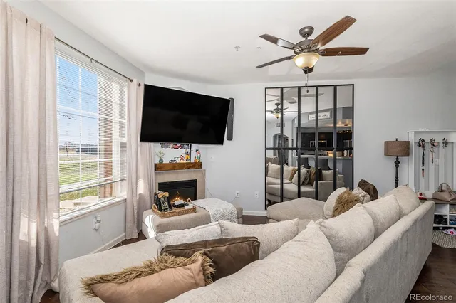a living room with furniture a flat screen tv and a floor to ceiling window