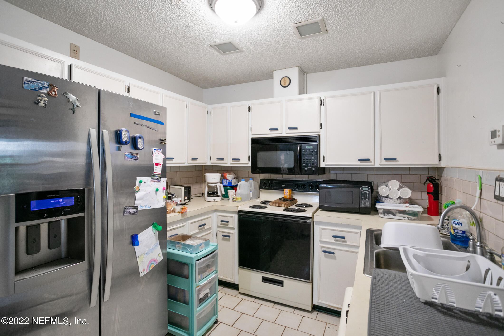3150 Ricky Drive Jacksonville, FL 32223 - Photo 16 of 28 a kitchen with stainless steel appliances kitchen island granite countertop a refrigerator stove and sink