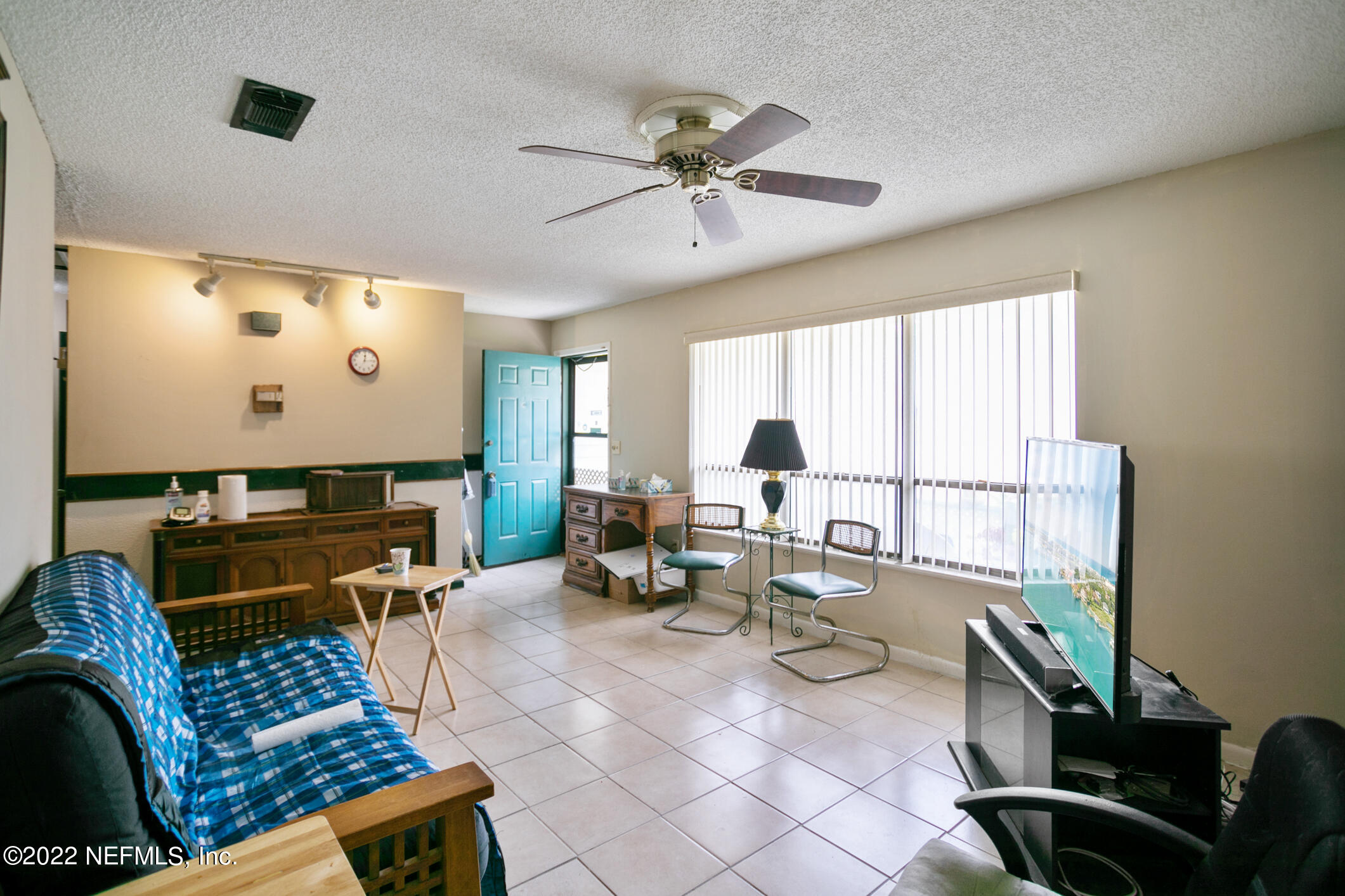 3150 Ricky Drive Jacksonville, FL 32223 - Photo 6 of 28 a living room with furniture a large window and a flat screen tv