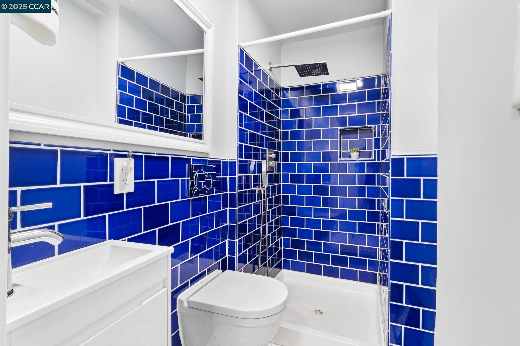 4010 Masterson Street Oakland, CA 94619 - Photo 17 of 27 a bathroom with a toilet a sink and mirror