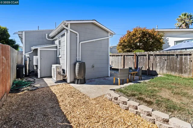 a view of a house with wooden fence next to a yard