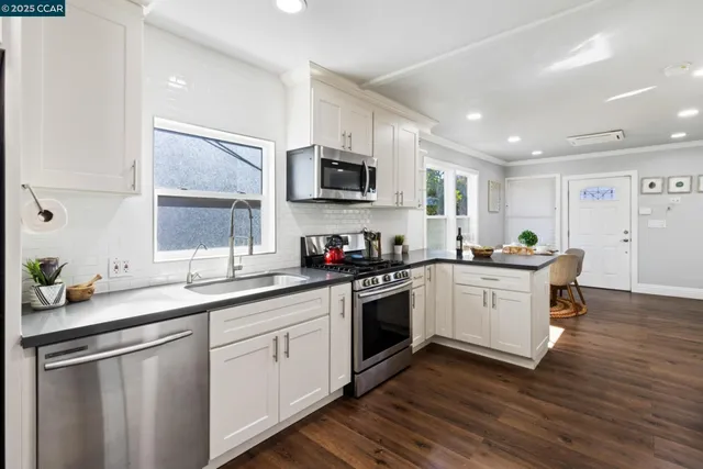 a kitchen with a sink cabinets and stainless steel appliances