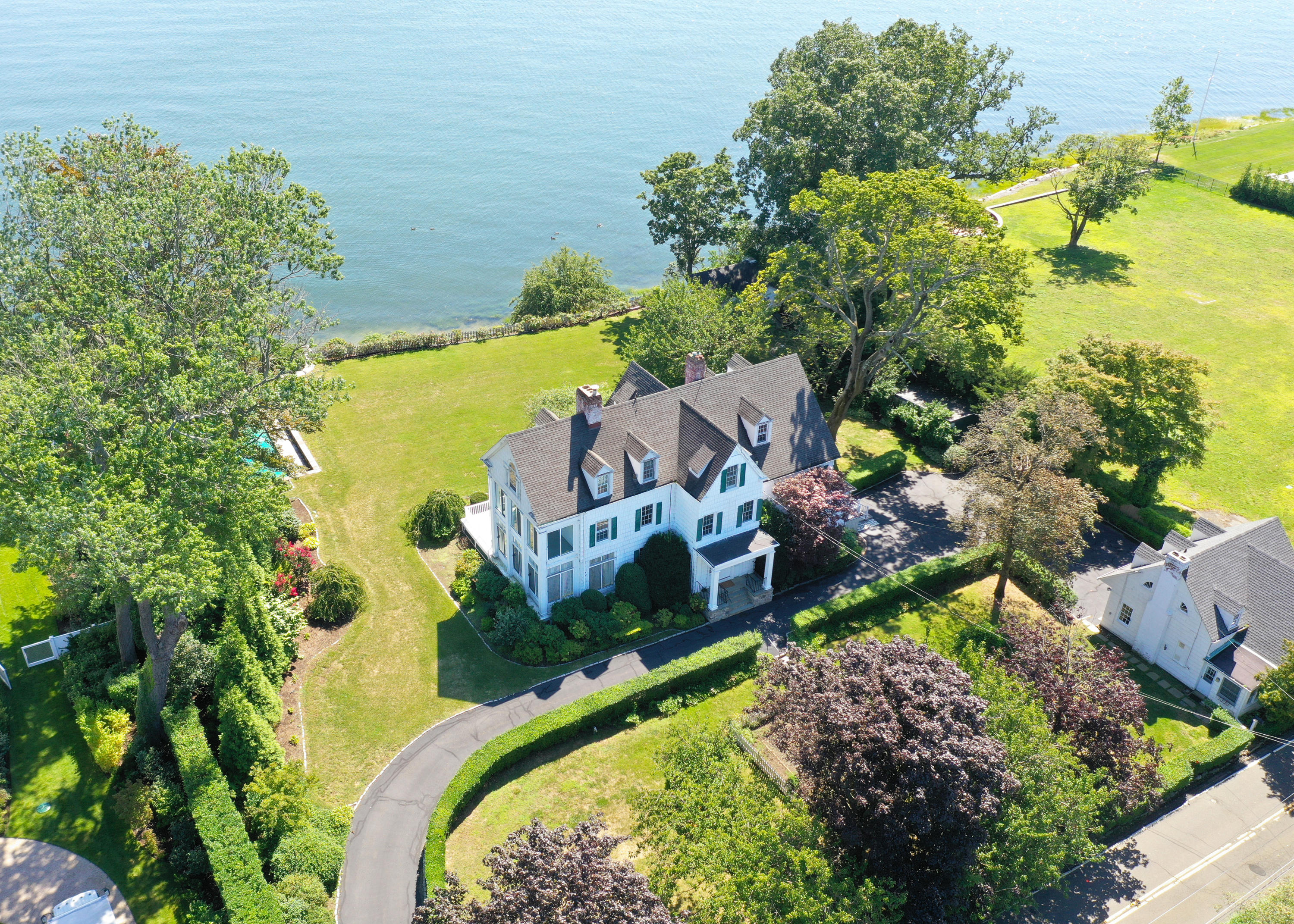 an aerial view of a house with a garden and lake view