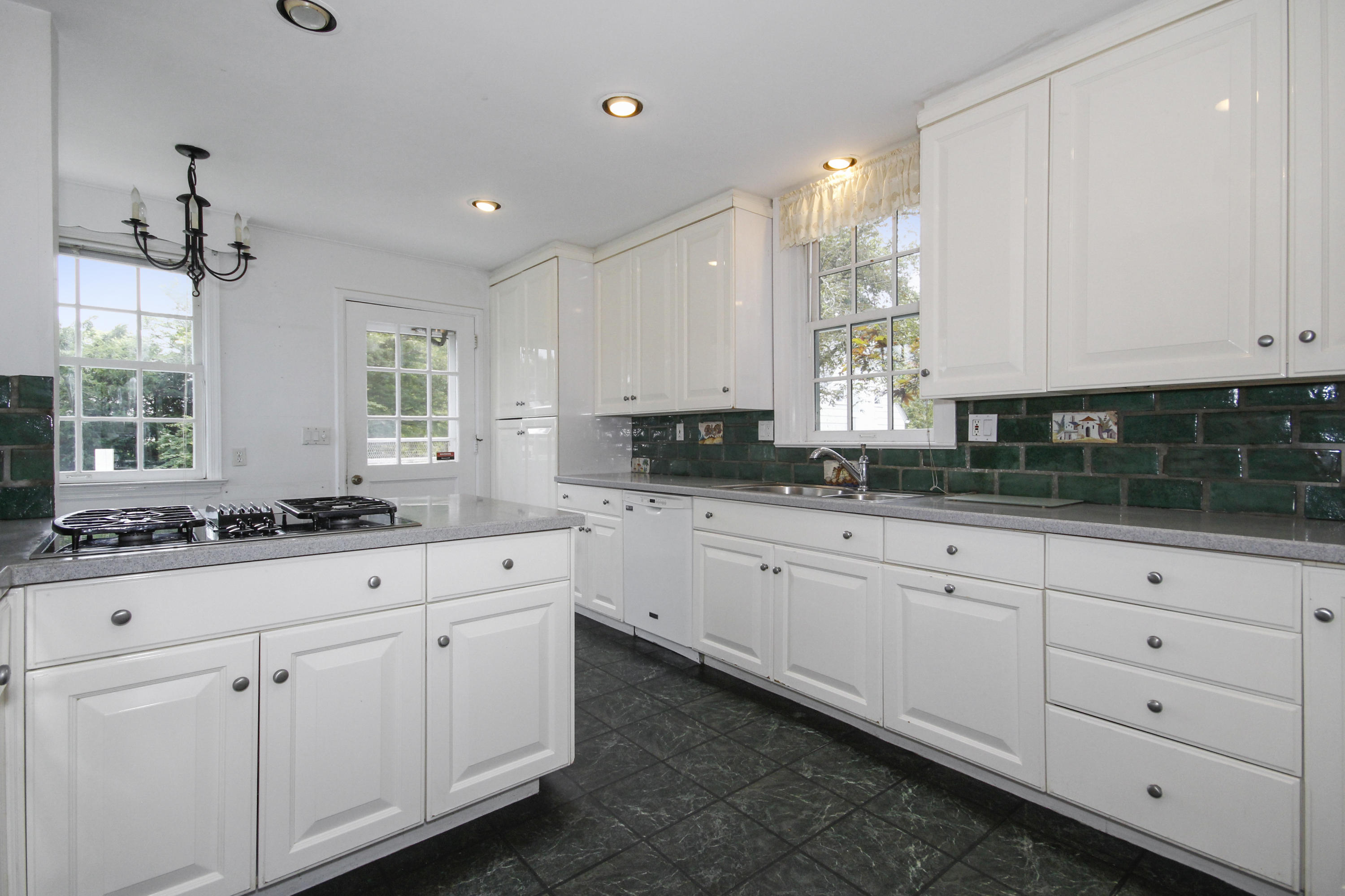 237 Long Neck Point Road Darien, CT 06820 - Photo 11 of 38 a kitchen with white cabinets and white appliances