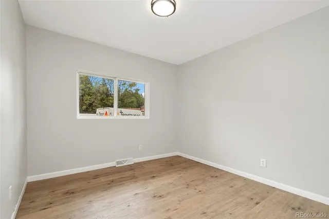a view of empty room with wooden floor