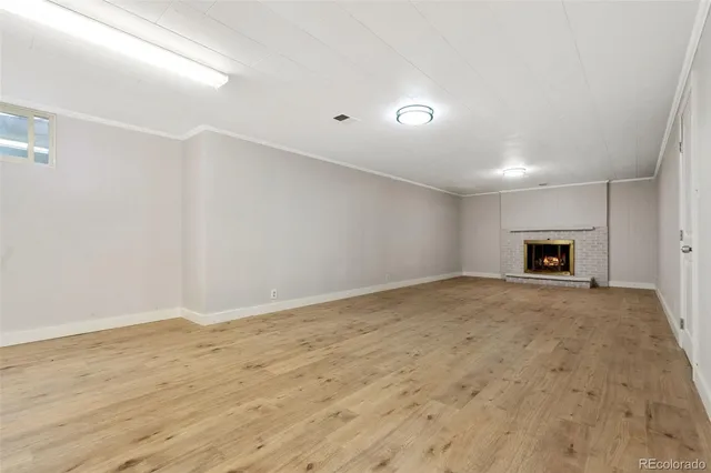 a view of empty room with wooden floor and fireplace
