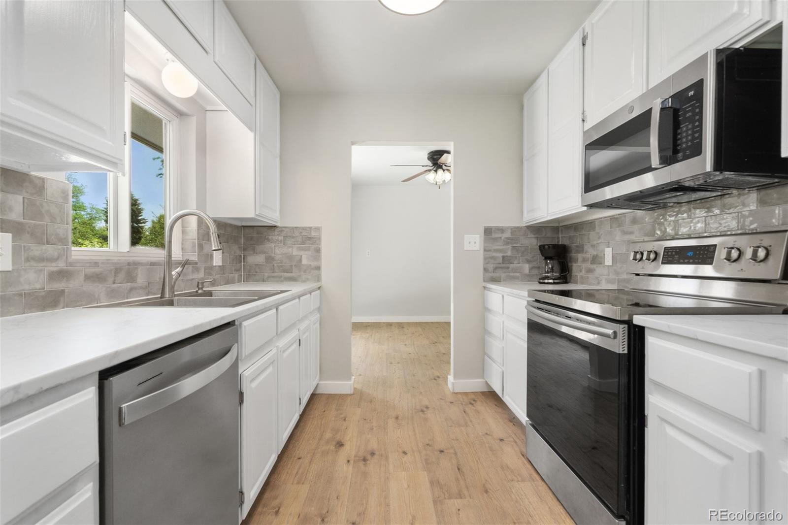 1304 South Lemay Avenue Fort Collins, CO 80524 - Photo 9 of 21 a kitchen with stainless steel appliances granite countertop a sink stove and microwave