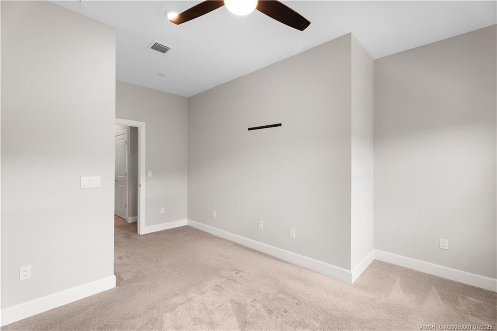 1857 Southeast Tarni Way Stuart, FL 34996 - Photo 14 of 21 an empty room with a ceiling fan and carpet