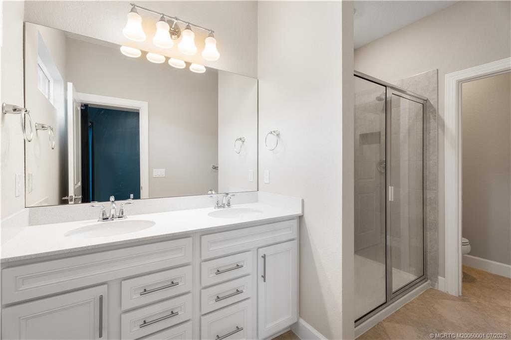 1857 Southeast Tarni Way Stuart, FL 34996 - Photo 20 of 21 a bathroom with a double vanity sink and a mirror