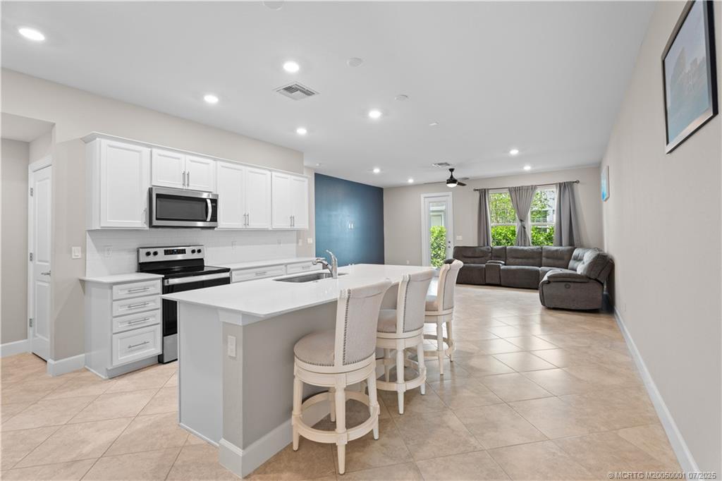 1857 Southeast Tarni Way Stuart, FL 34996 - Photo 5 of 21 a kitchen with furniture a microwave a stove and a refrigerator