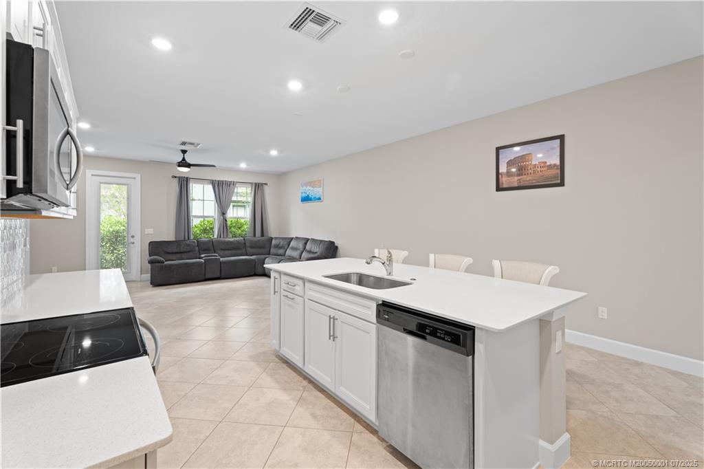 1857 Southeast Tarni Way Stuart, FL 34996 - Photo 9 of 21 a large white kitchen with a sink and a stove top oven with wooden floor