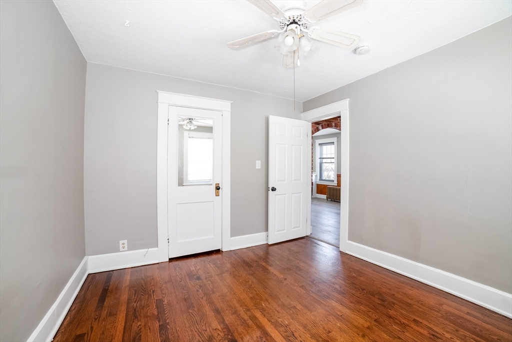 5 Maple Avenue, Unit 2 Oxford, MA 01537 - Photo 20 of 22 an empty room with wooden floor chandelier fan and windows