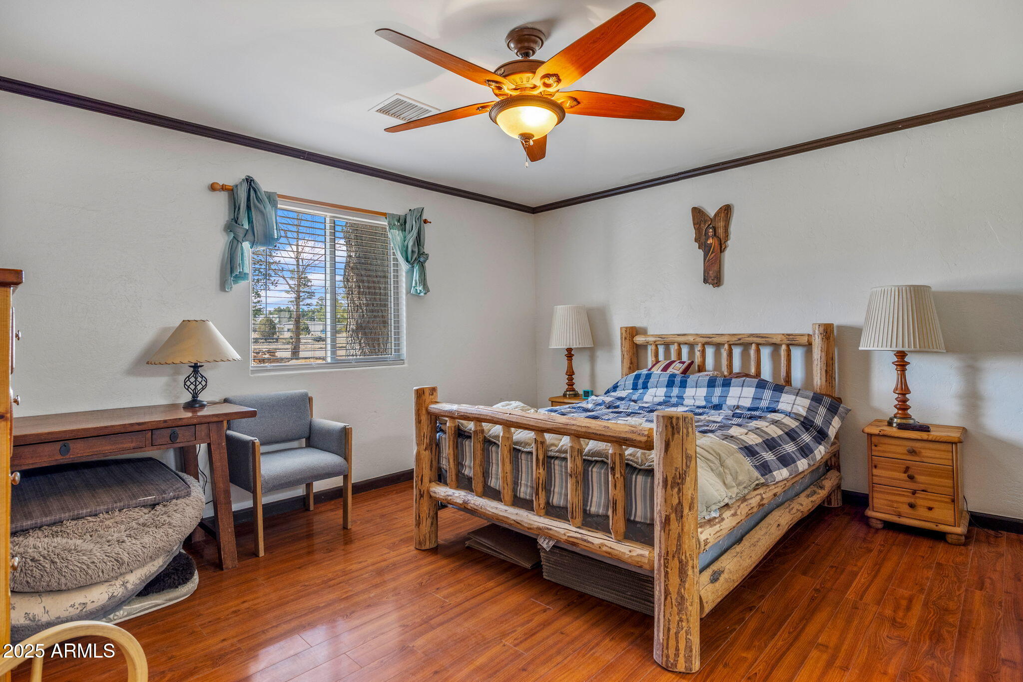 2727 Pine Meadow Drive Overgaard, AZ 85933 - Photo 14 of 34 a bedroom with a bed and a chandelier