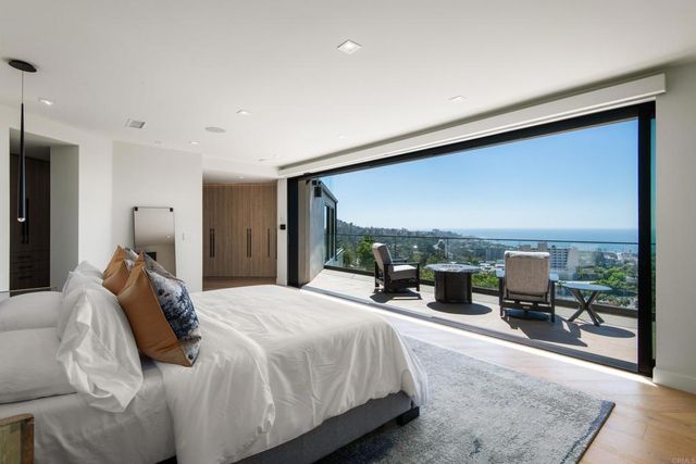 a bedroom with a bed and large windows