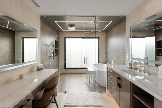 a bathroom with a double vanity sink a mirror and a bathtub